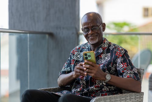 Elderly man using a smartphone to do internet banking